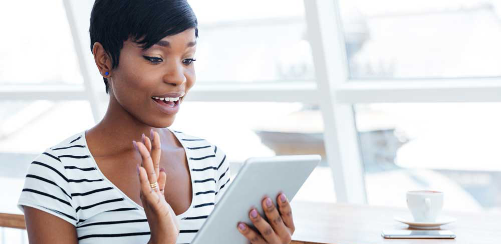 Happy afro american businesswoman holding tablet computer and wa